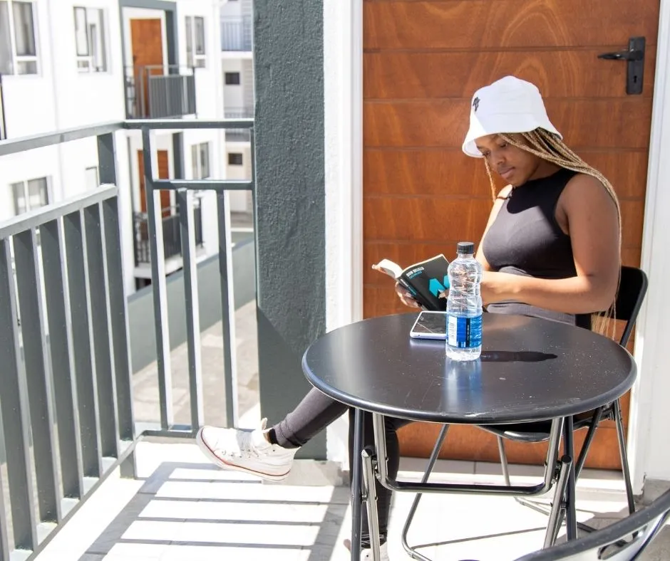 A student reading on her balcony