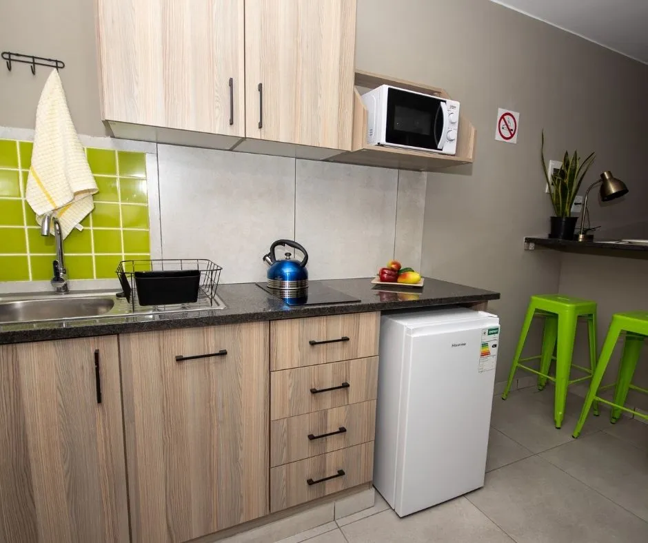 A shared kitchen with fridge, microwave and cupboards